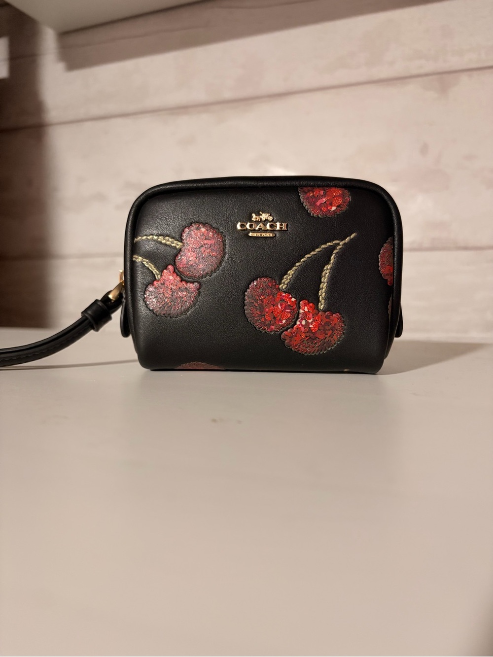 CDF01 Coach black wristlet/pouch with sequin cherries print